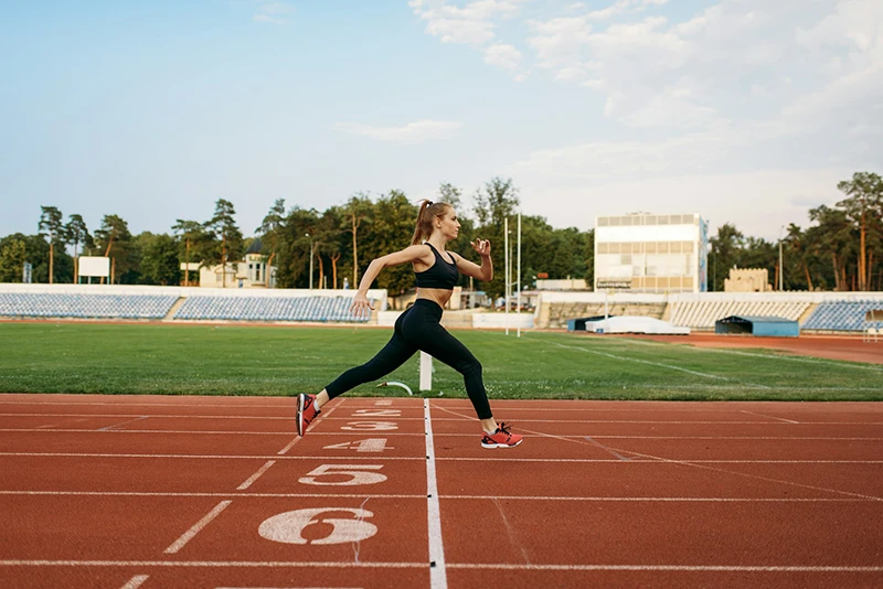 Female runner crosses finish line on stadium