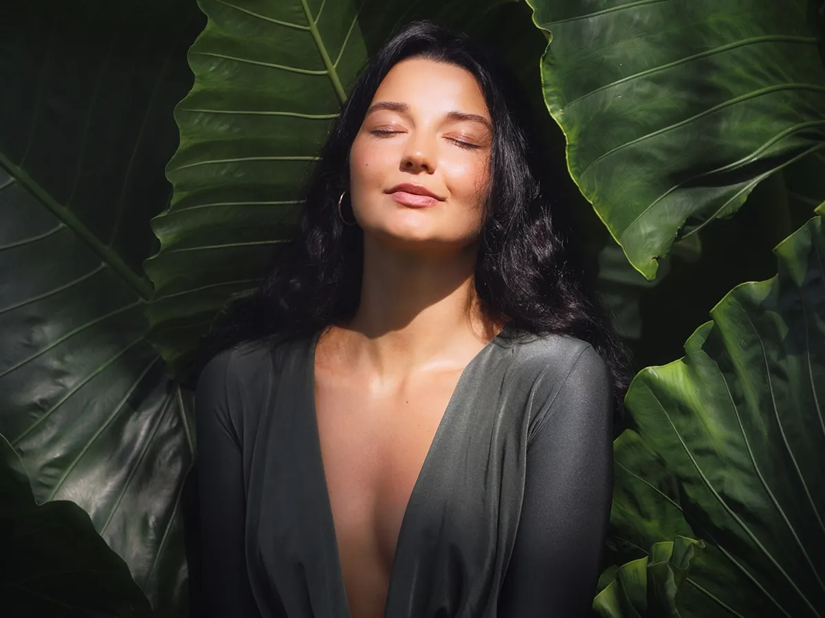 Woman relaxing among tropical leaves