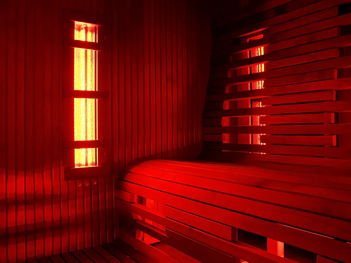Wooden infrared sauna interior illuminated by therapeutic red light